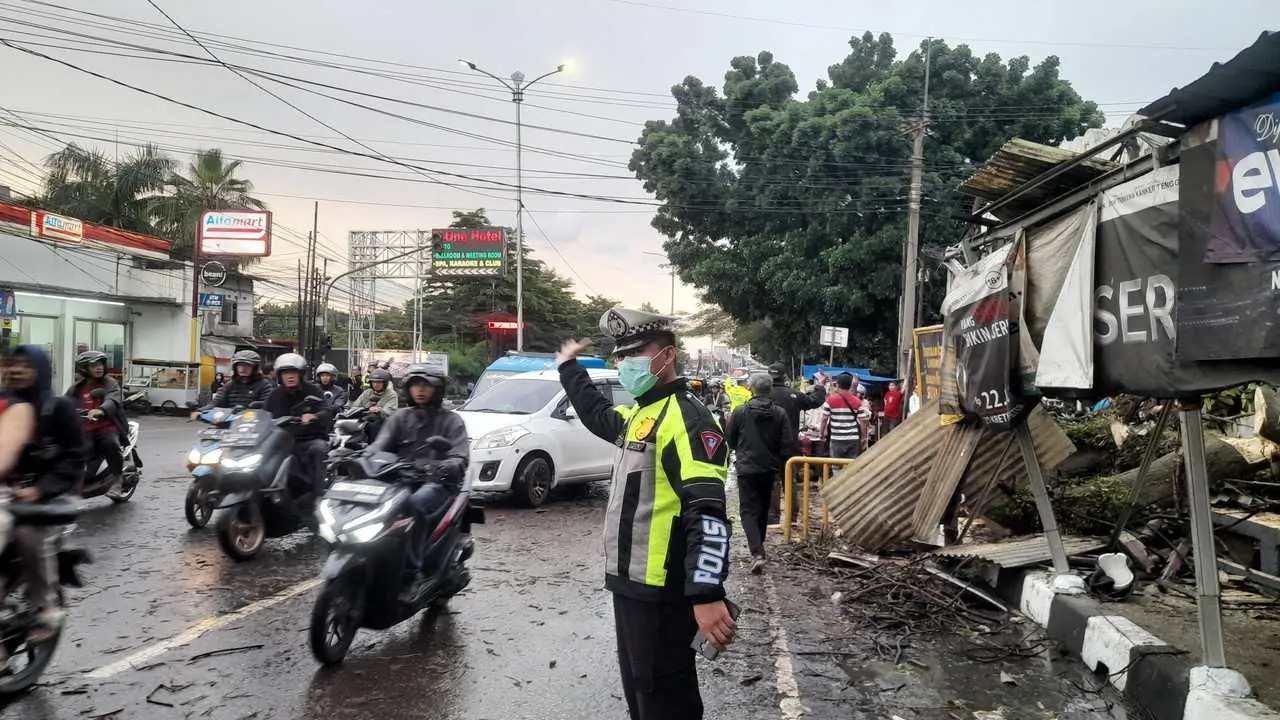 Anggota Polsek Sukaraja Polres Bogor Bantu Evakuasi Pohon Tumbang dan Atur Lalu Lintas di Jembatan Hitam