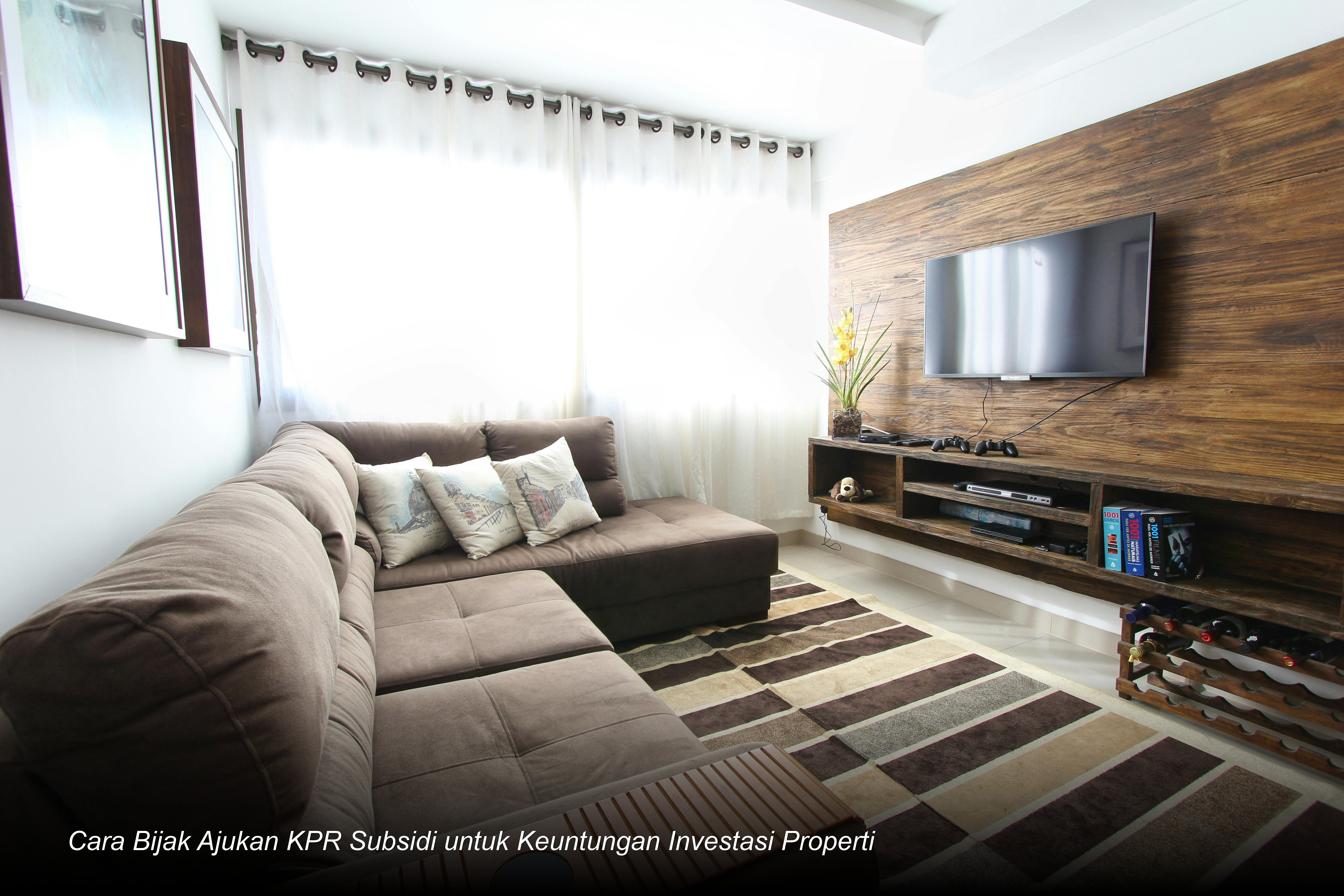 Seorang pasangan muda tersenyum bahagia saat menandatangani dokumen akad kredit KPR di hadapan notaris dan petugas bank.
