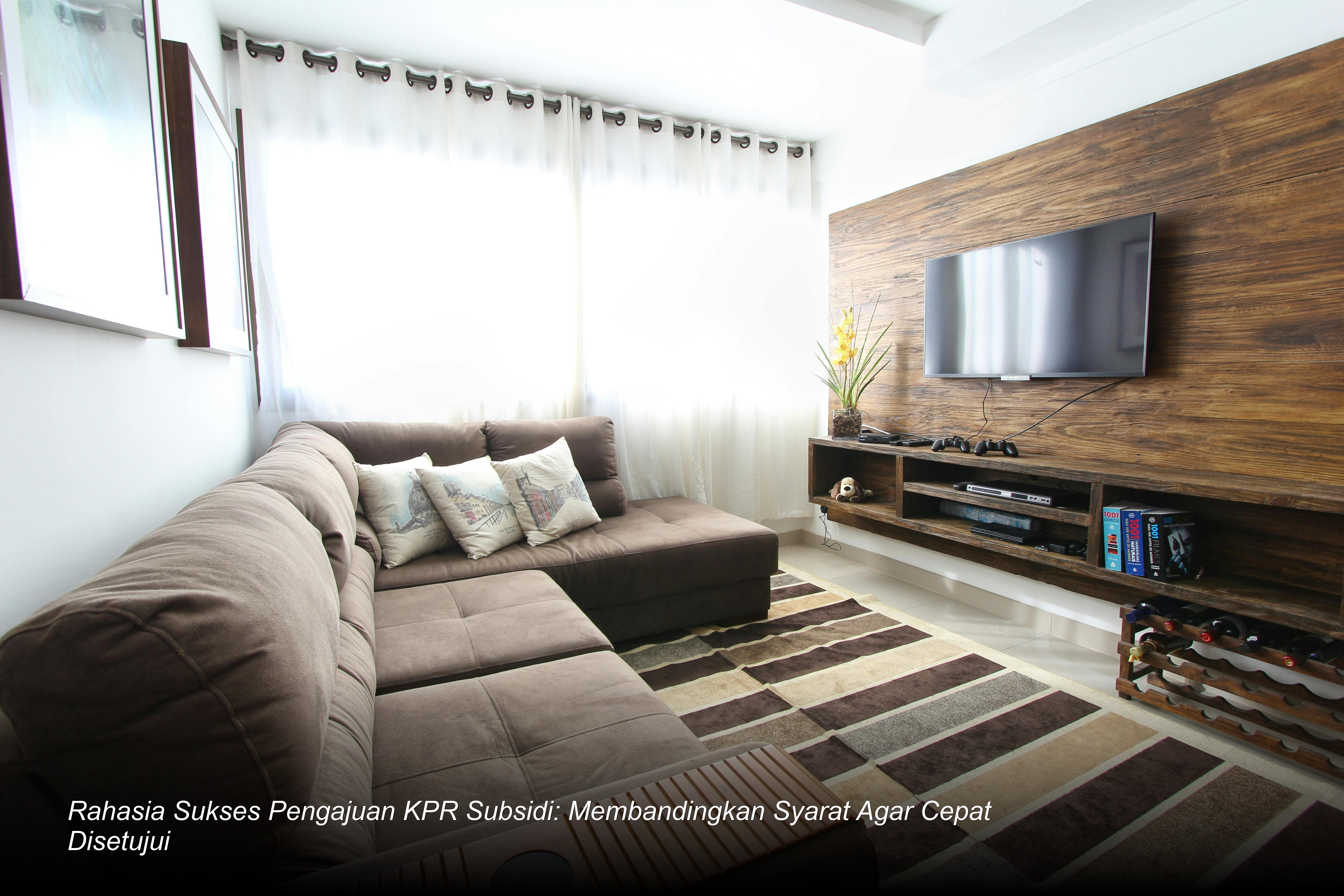 Seorang profesional muda sedang menandatangani dokumen akad kredit KPR subsidi bersama petugas bank di depan model rumah minimalis modern.